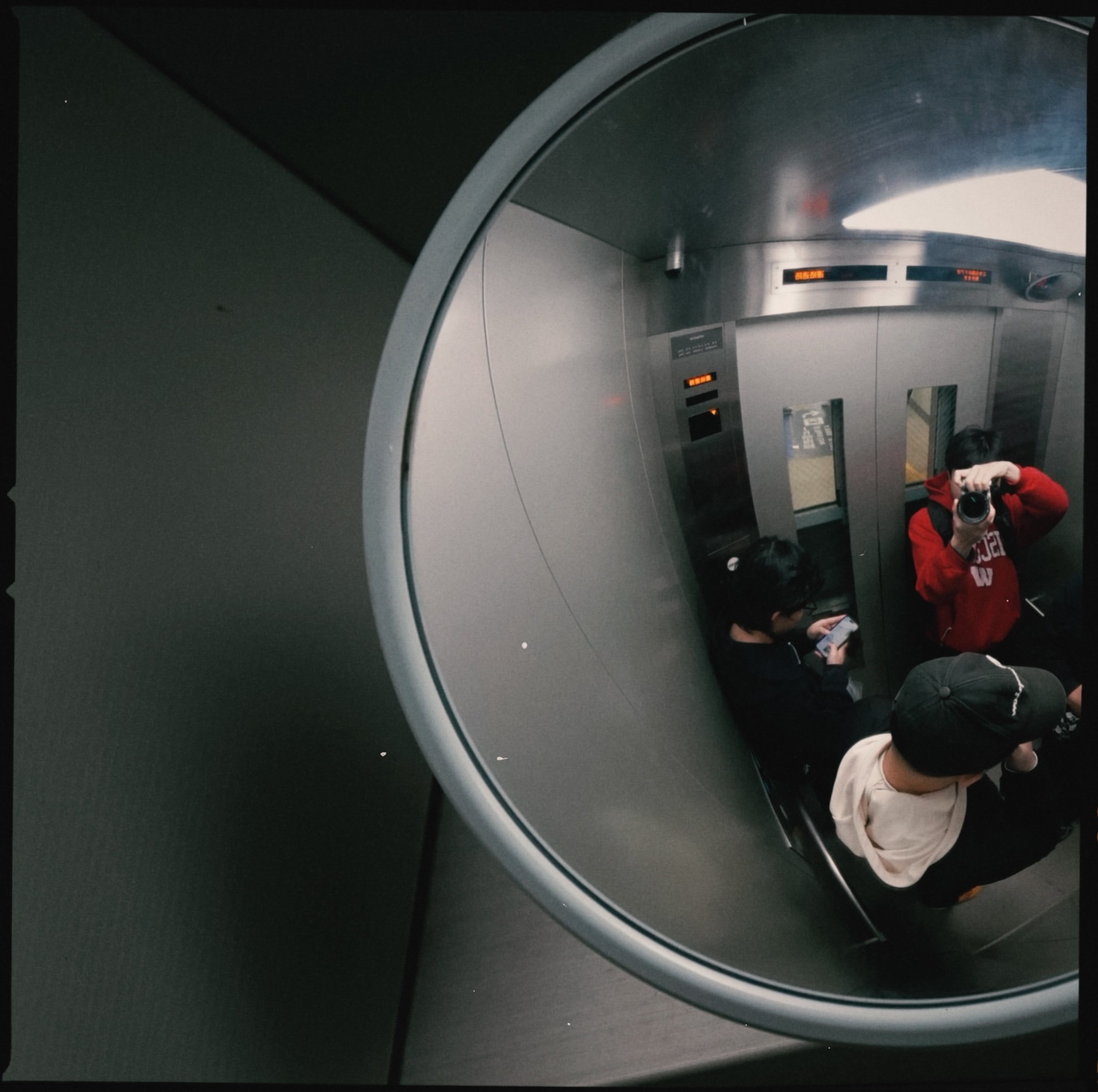 People reflected in a convex indoor mirror
